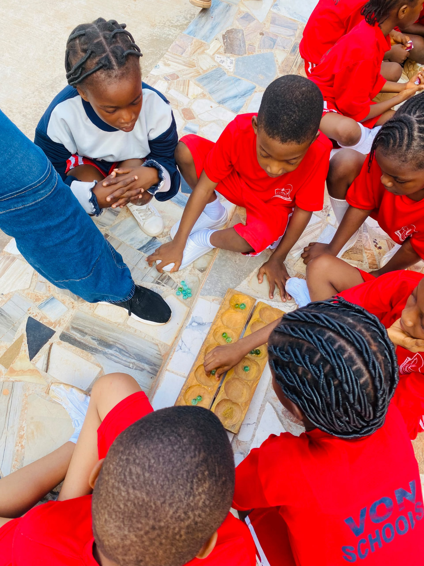 Vonschools students playing a traditional wooden board game