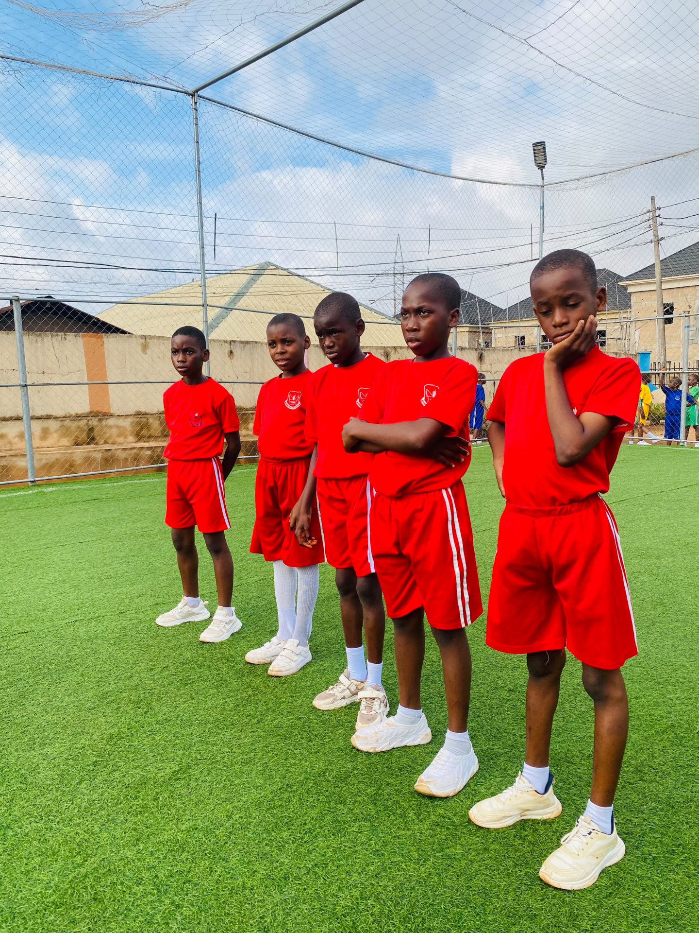 Vonschools students in red sports kits lined up on the pitch